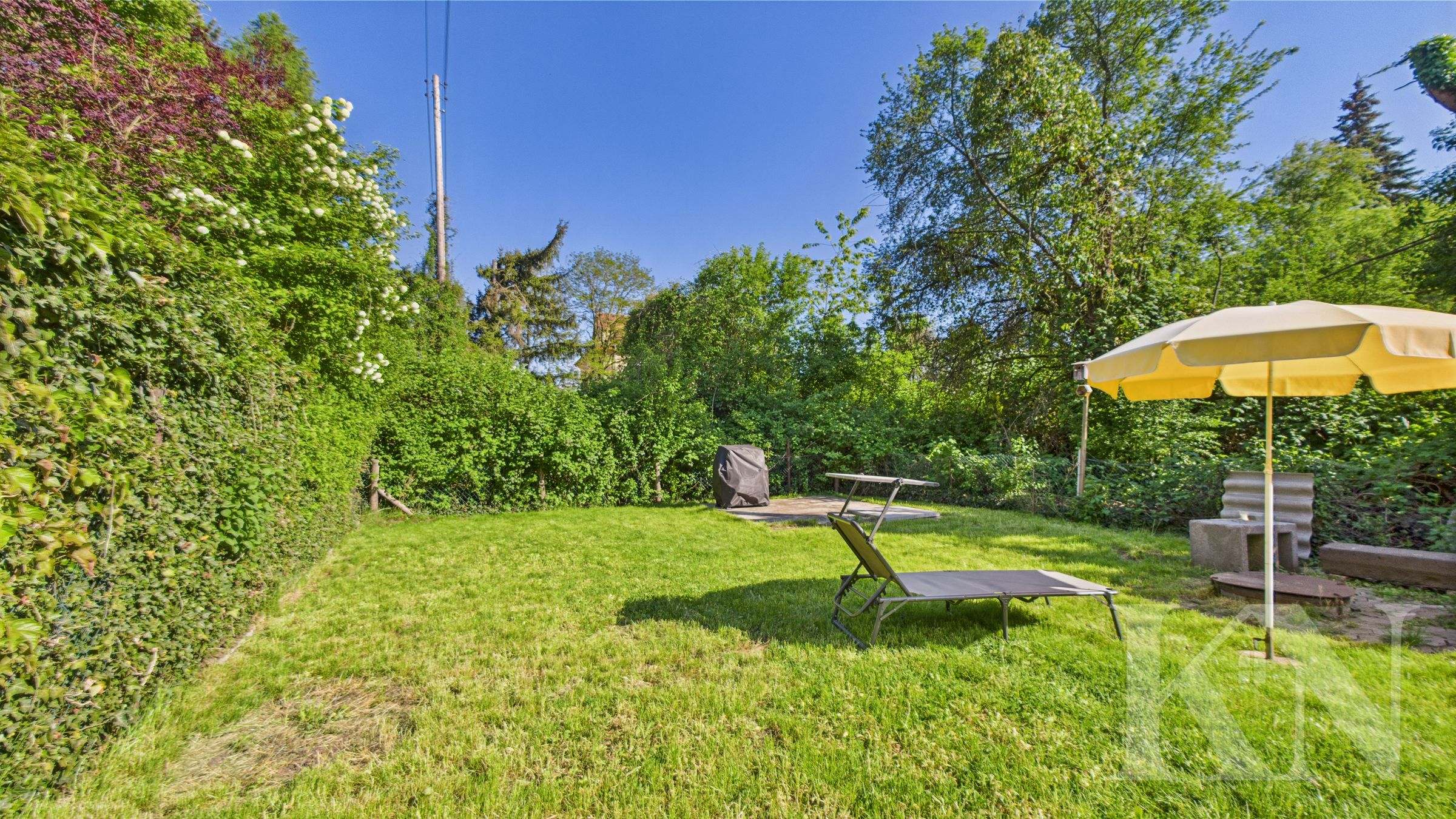 Garten hinter dem Haus mit Rasen und Hecke